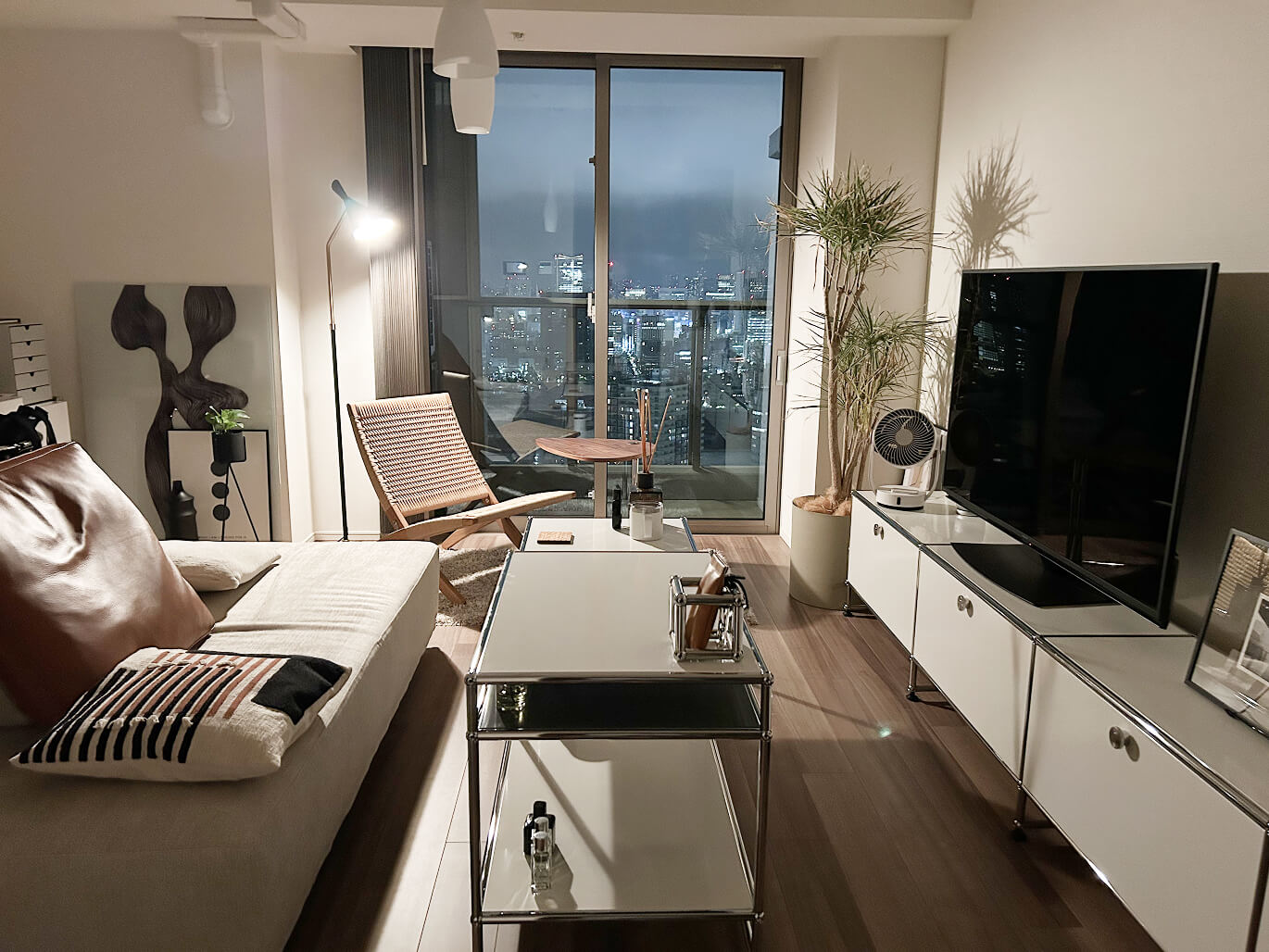 大きな窓から都会の夜景を望む、洗練されたリビングルーム