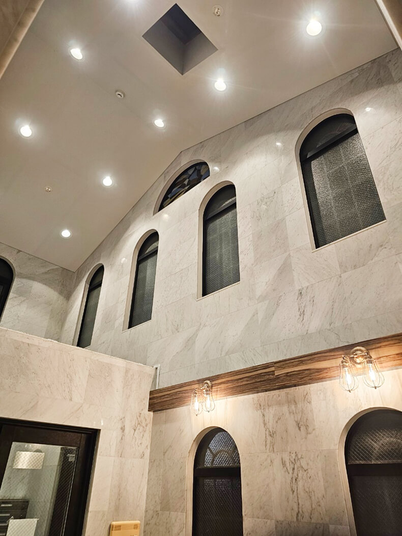 アーチ型の窓と大理石風の壁が美しい開放的な吹き抜け空間