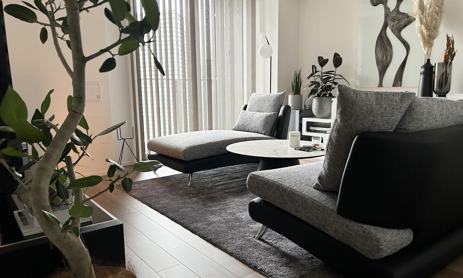 グレーのソファと観葉植物が並ぶ開放的なリビング。