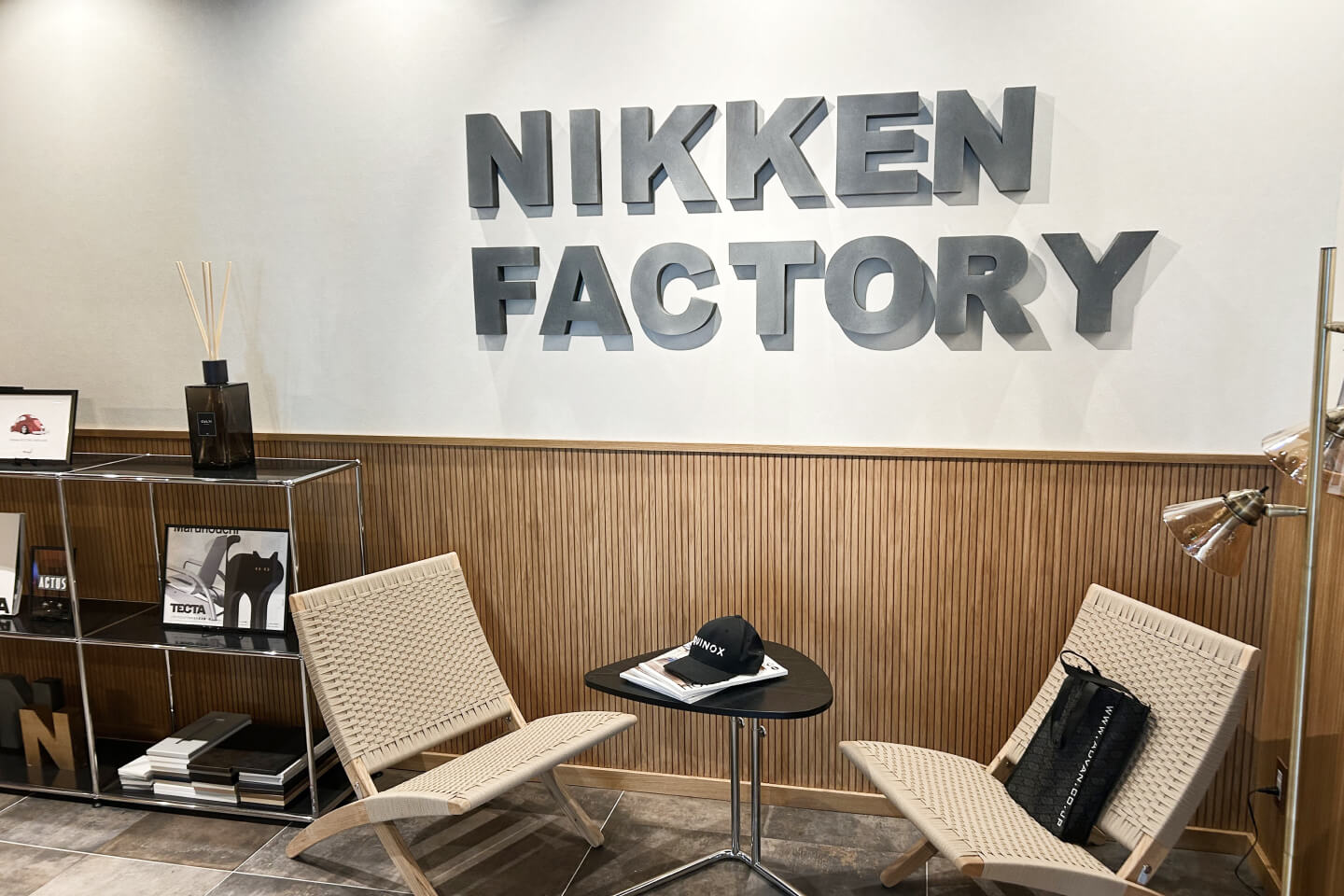 木製パネルの壁に立体的な社名ロゴを配したエリア。