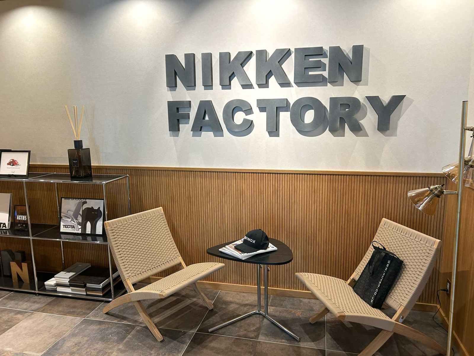 木製パネルの壁に立体的な社名ロゴを配したエリア。