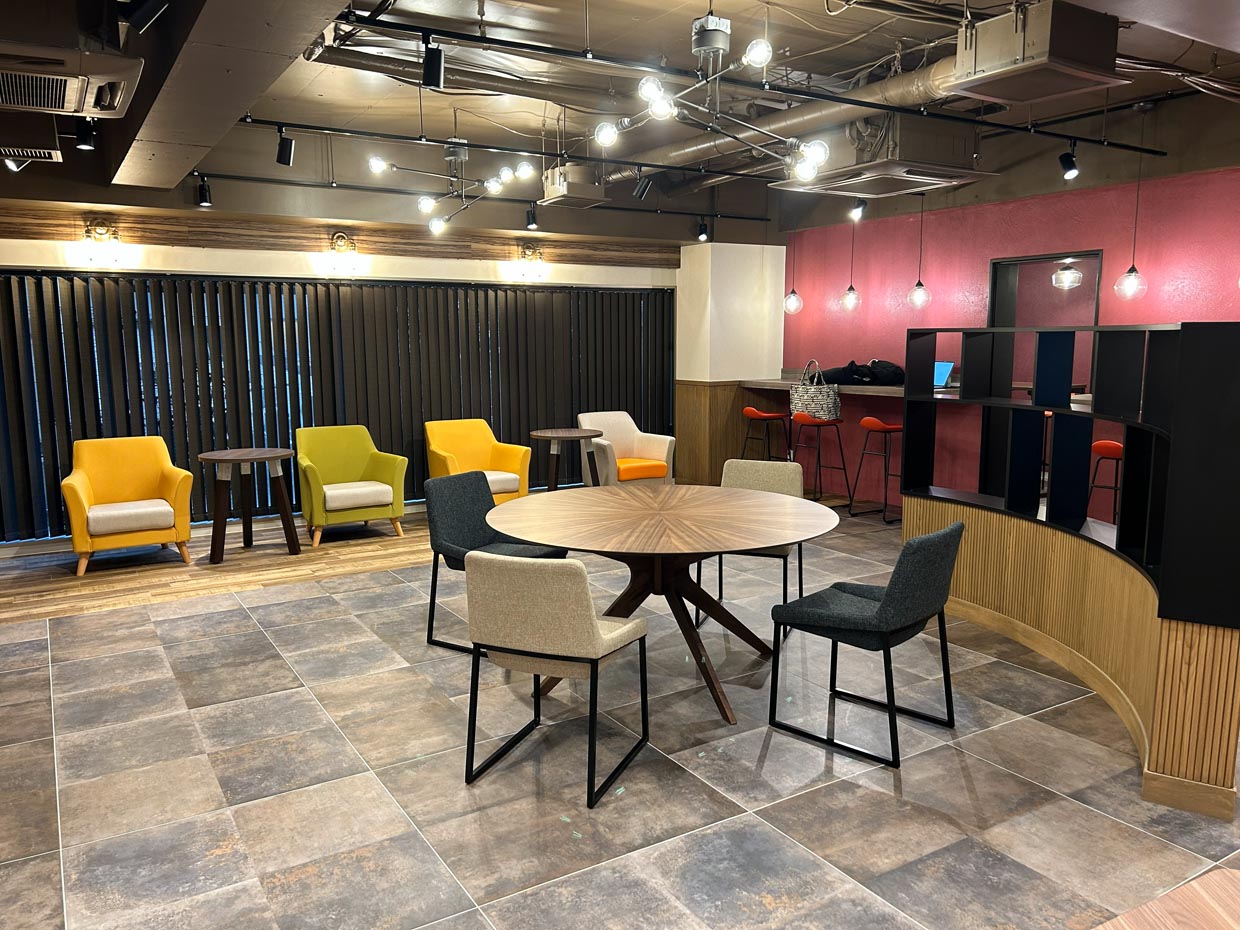 黄色や緑の椅子とボルドーの壁が印象的なモダンな室内