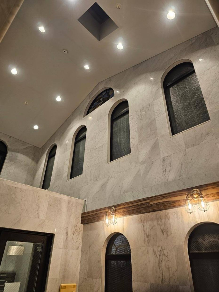 アーチ型の窓と大理石風の壁が美しい開放的な吹き抜け空間