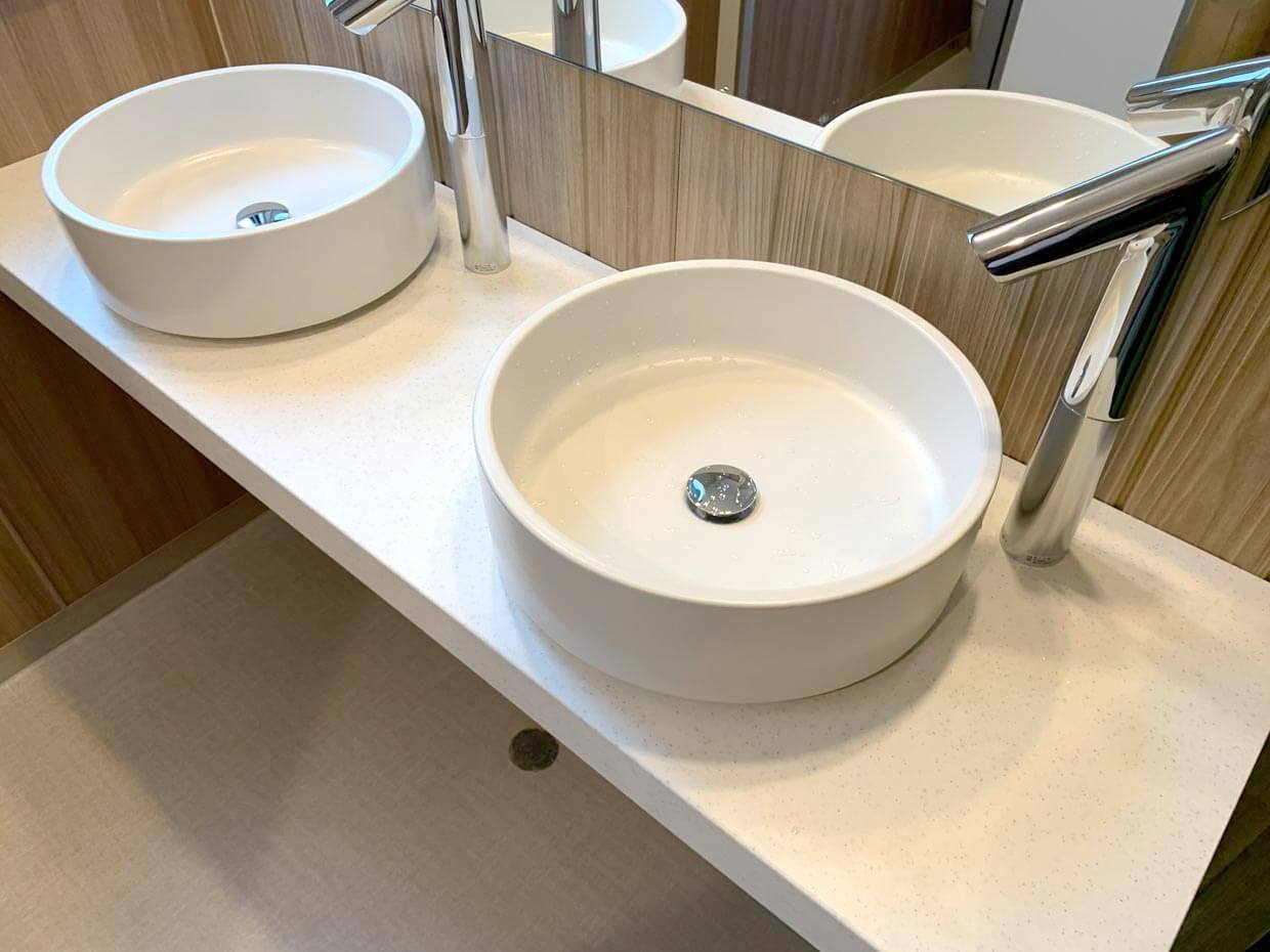 洗面ボウル（俯瞰）： カウンターに設置された、丸く白い清潔感のある洗面ボウル。